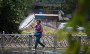 Женщина с зонтом во время дождя.