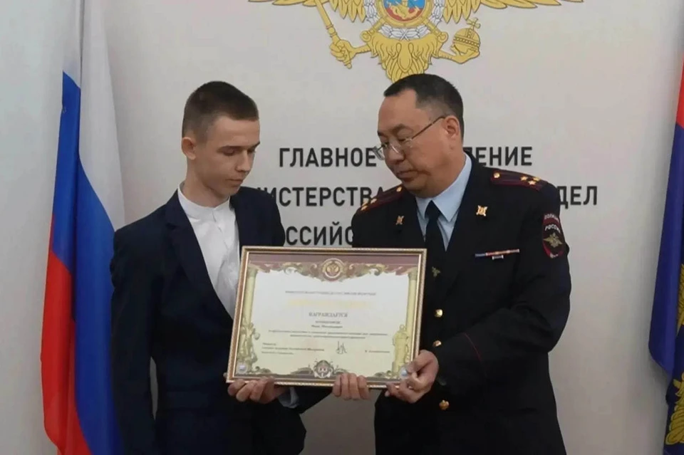 Школьник Иван получает награду.