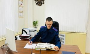 Следователь-криминалист за рабочим столом.