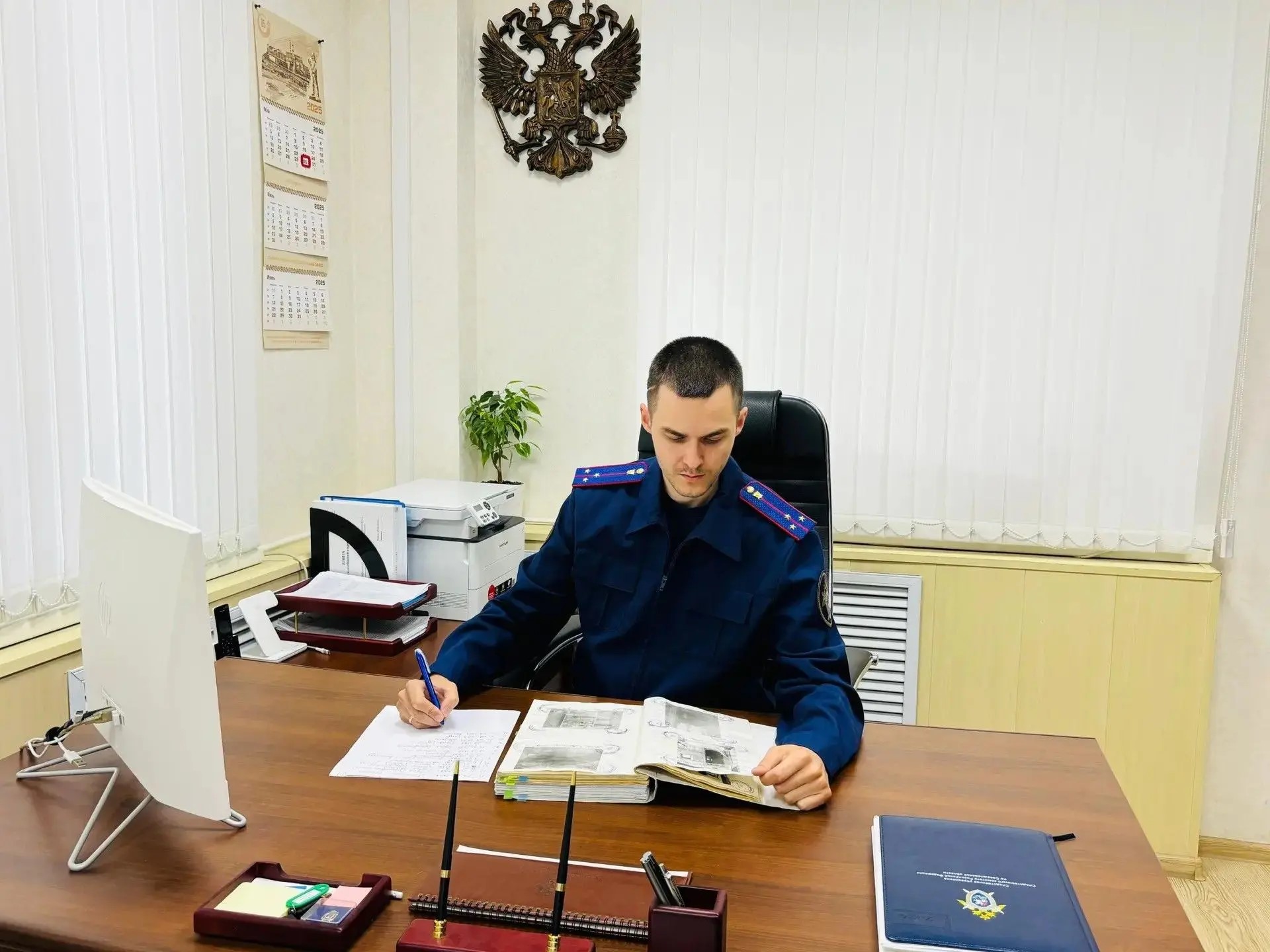 Следователь-криминалист за рабочим столом.