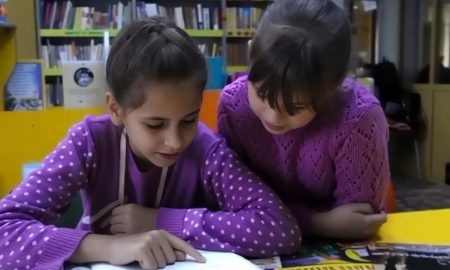 Школьницы читают книгу