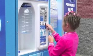 Девочка набирает воду в водомате