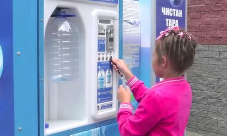 Девочка набирает воду в водомате
